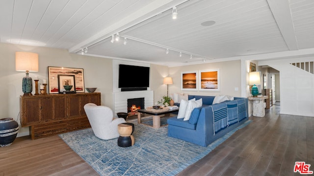 living room with rail lighting, wood-type flooring, and beamed ceiling