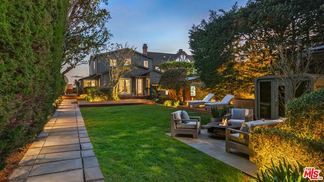 back of property featuring a yard, a patio, and an outdoor hangout area