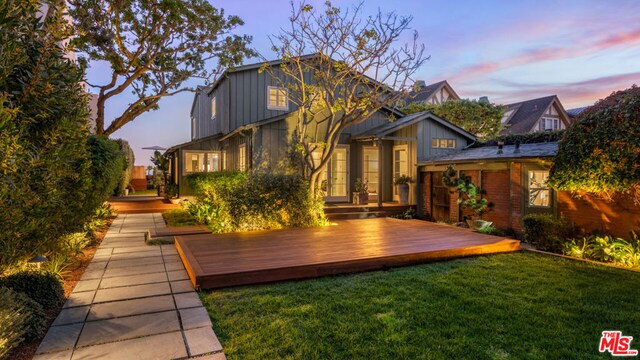 view of front of house with a deck and a lawn