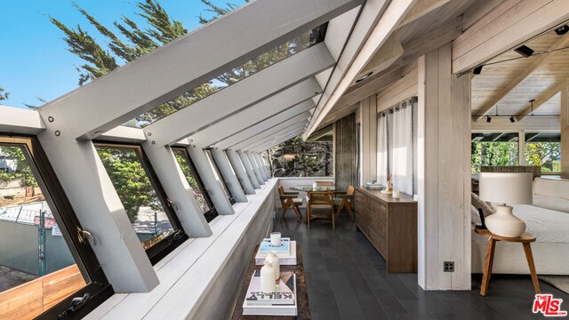 sunroom with a wealth of natural light and vaulted ceiling with beams