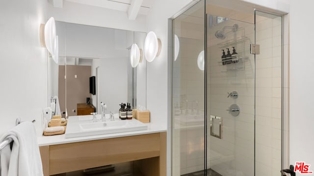 bathroom featuring a shower with door and vanity