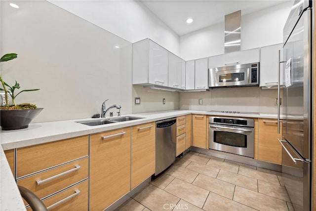 kitchen featuring sink, appliances with stainless steel finishes, white cabinetry, and light tile patterned floors