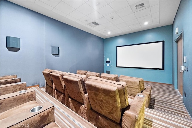 carpeted cinema room featuring a drop ceiling