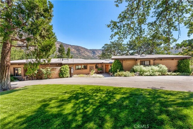 view of front facade featuring a mountain view and a front yard