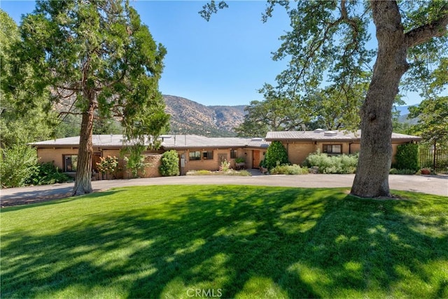 view of front of property featuring a mountain view and a front lawn