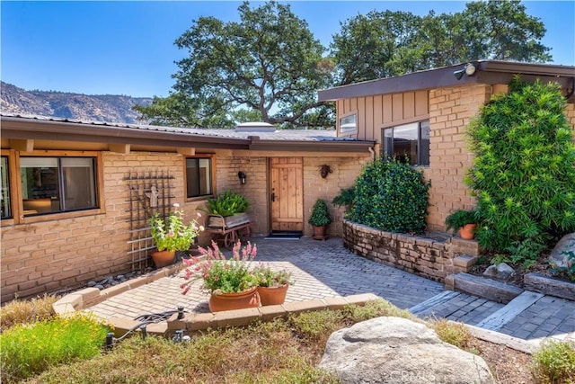 doorway to property featuring a mountain view and a patio