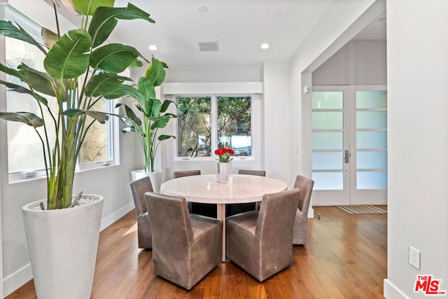 dining area with wood-type flooring and french doors