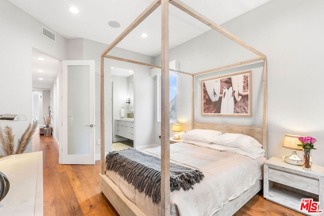 bedroom featuring light hardwood / wood-style floors and ensuite bath