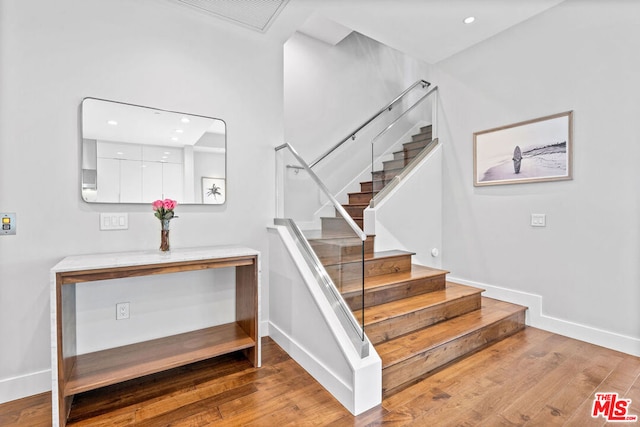 stairway with hardwood / wood-style floors