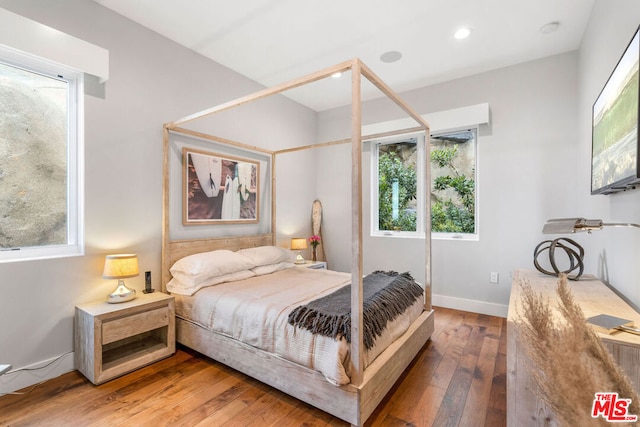 bedroom featuring hardwood / wood-style flooring and multiple windows