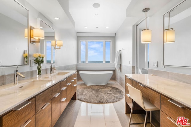 bathroom with a bathtub, tile patterned flooring, and vanity