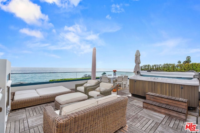 wooden deck with a water view and a hot tub