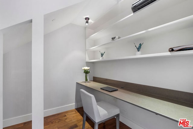 office area featuring lofted ceiling, wood-type flooring, and built in desk