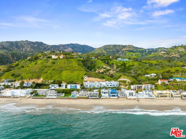 aerial view featuring a view of the beach and a water and mountain view