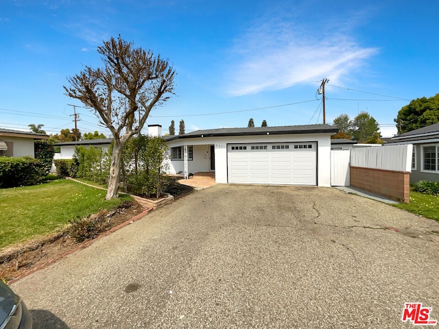 single story home featuring a garage and a front lawn