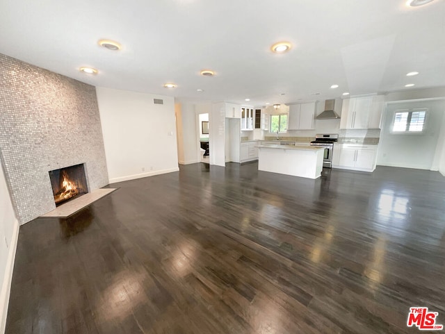 unfurnished living room with a large fireplace and dark hardwood / wood-style floors