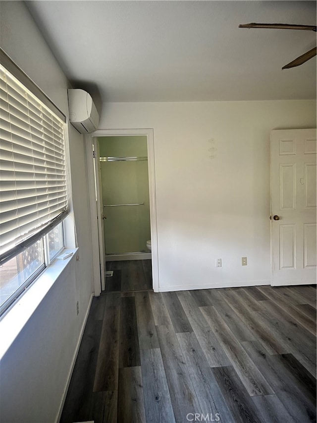 interior space featuring ceiling fan, dark wood-type flooring, and a wall unit AC