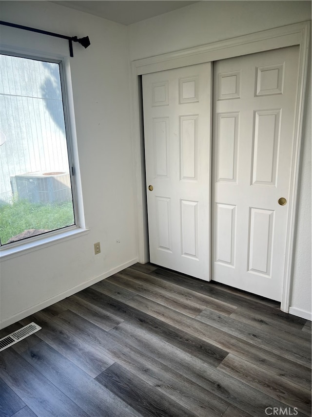 unfurnished bedroom with a closet and dark hardwood / wood-style floors