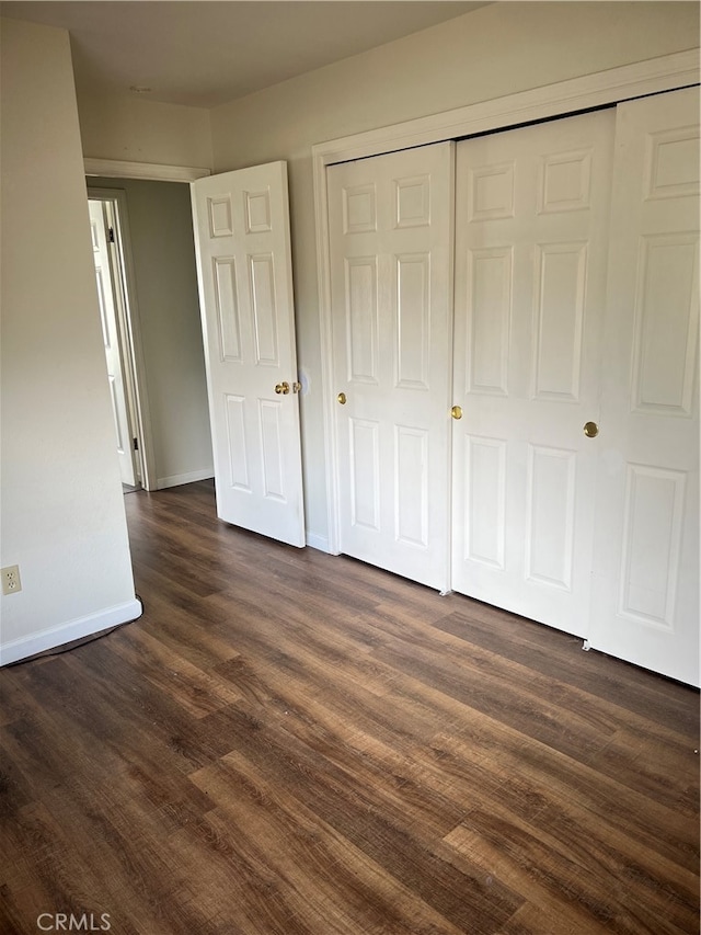 unfurnished bedroom featuring a closet and dark hardwood / wood-style floors