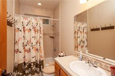 full bathroom with shower / bathtub combination with curtain, vanity, and toilet