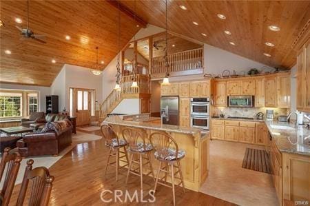 kitchen with stainless steel appliances, beam ceiling, high vaulted ceiling, wooden ceiling, and hanging light fixtures