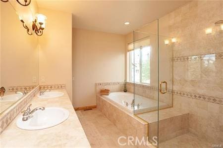 bathroom featuring sink, independent shower and bath, and a chandelier