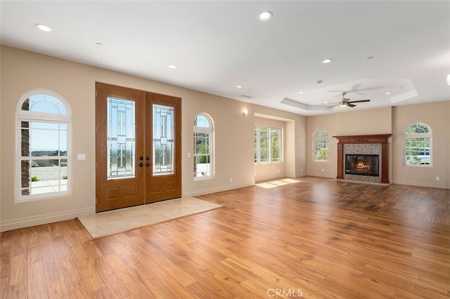 entrance foyer featuring ceiling fan, a tray ceiling, french doors, and light hardwood / wood-style floors