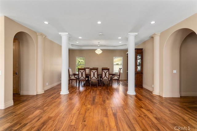 dining space featuring decorative columns and hardwood / wood-style floors