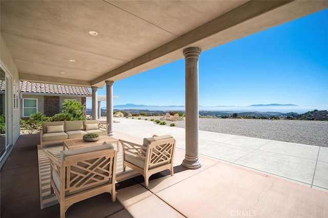 view of patio with an outdoor living space and a mountain view