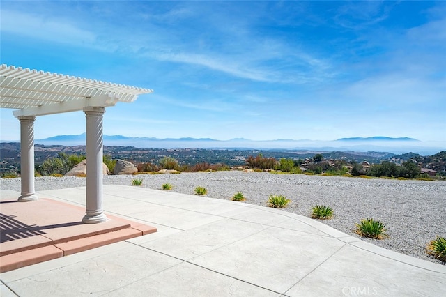 view of patio with a mountain view and a pergola