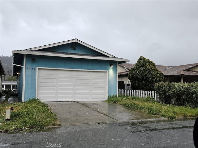 exterior space with concrete driveway and fence