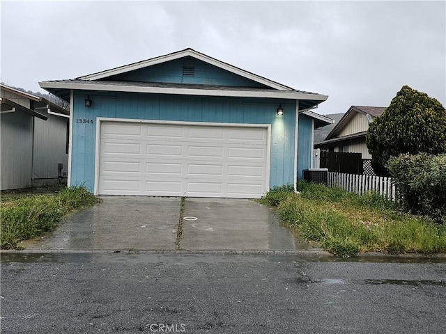 garage with fence and driveway