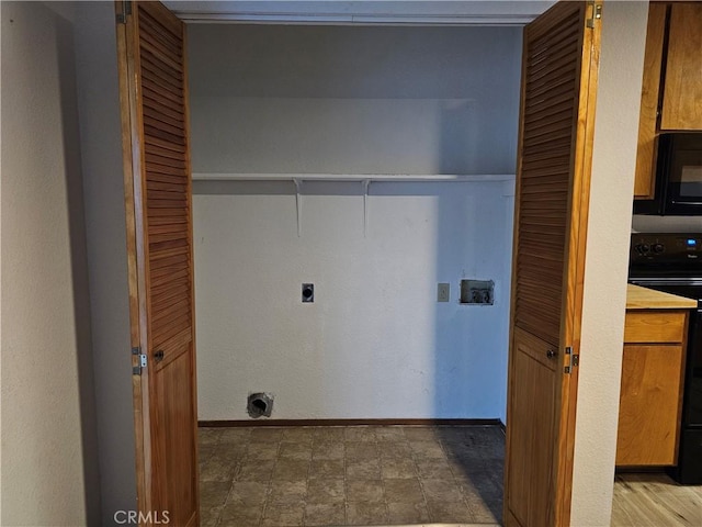 clothes washing area with laundry area, electric dryer hookup, and baseboards