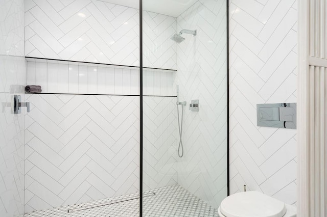 bathroom featuring toilet and a tile shower