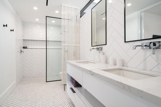 bathroom with tile patterned flooring, vanity, tile walls, toilet, and tiled shower