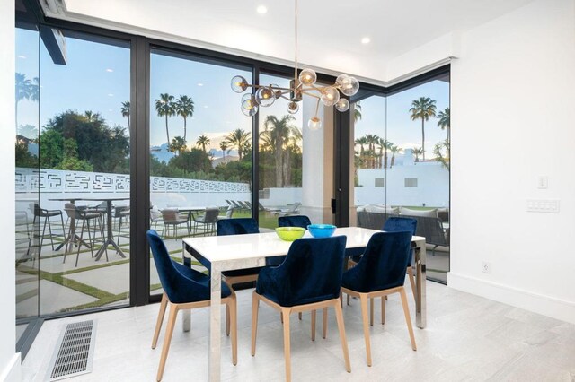 dining area featuring expansive windows and a notable chandelier