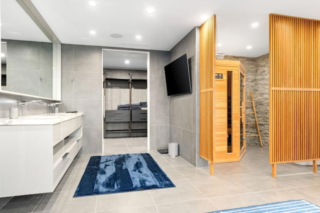 bathroom featuring tile patterned flooring, tile walls, and vanity