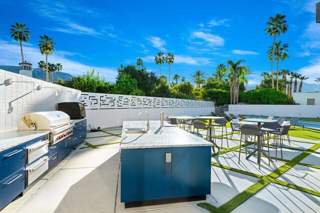 view of patio / terrace featuring exterior kitchen and a grill