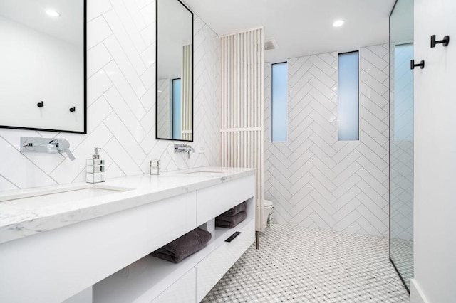 bathroom featuring tile patterned flooring, tile walls, vanity, and a tile shower