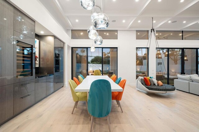 dining area featuring light hardwood / wood-style floors and coffered ceiling