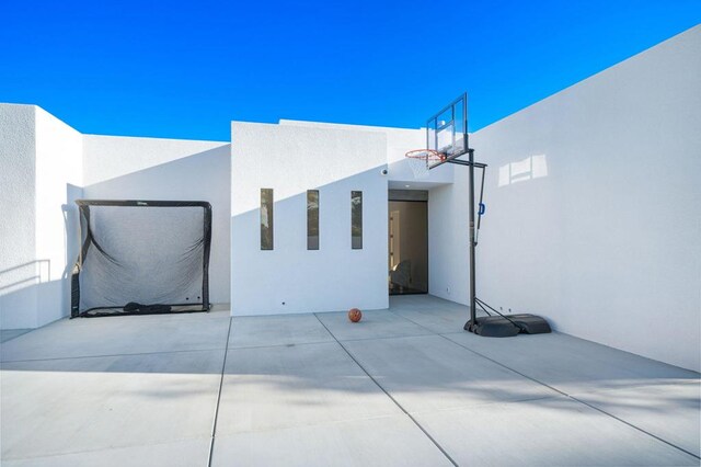 view of property exterior featuring basketball court