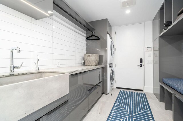 laundry area featuring stacked washer and dryer and sink