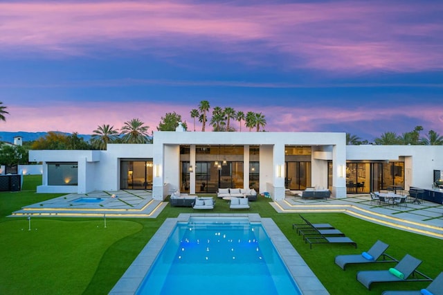 back house at dusk featuring an outdoor living space and a patio area