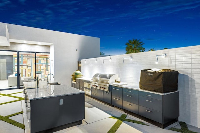 view of patio with sink, an outdoor kitchen, and grilling area