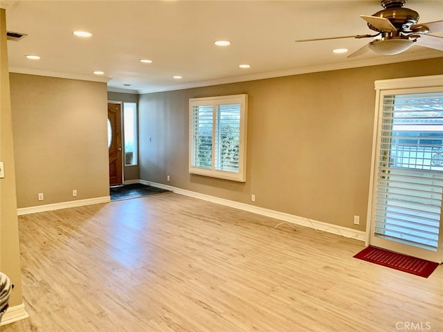 spare room featuring crown molding, light wood-type flooring, and ceiling fan