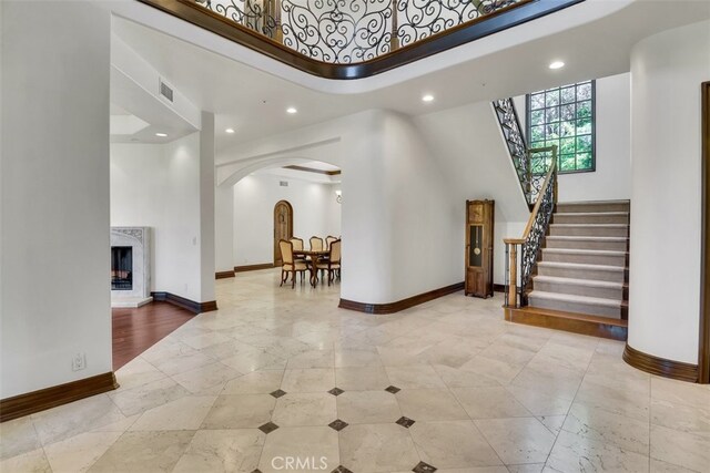 foyer featuring a high end fireplace and a high ceiling