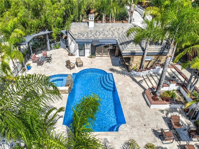 view of swimming pool featuring a patio area and an in ground hot tub