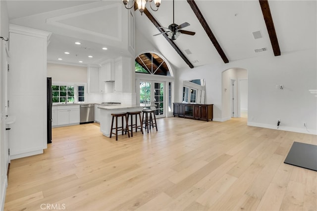 kitchen featuring a kitchen island, white cabinetry, decorative backsplash, a breakfast bar, and stainless steel dishwasher