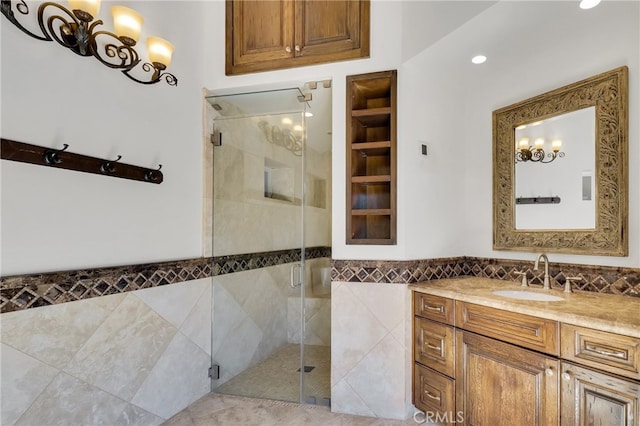 bathroom featuring tile walls, an enclosed shower, and vanity