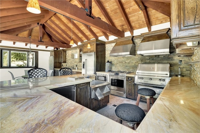 kitchen featuring light stone countertops, wall chimney range hood, stainless steel appliances, and beamed ceiling